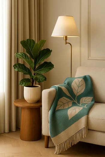 Bakıda mənzildə divan küncündə bitkilər, şam və lampadan ibarət Lumen & Leaf seti