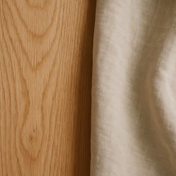 Taxta masa, kətan parça və neytral dekor elementləri bir kompozisiyada